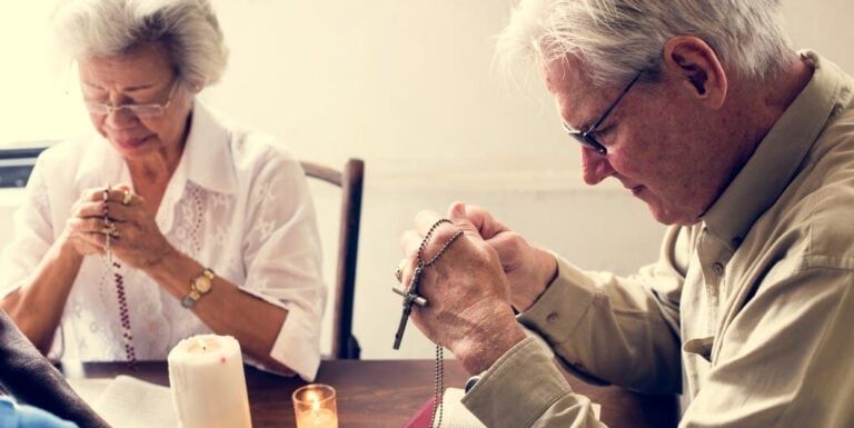 Elderly Couple Praying with Rosary Beads at a Memory Care Facility