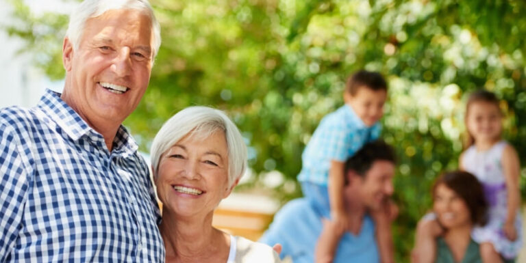 Elderly Couple Smiling With Family Outdoors at Assisted Living Facility